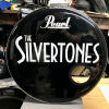 Black bass drum head with the Pearl logo and band name both in silver sparkle vinyl.